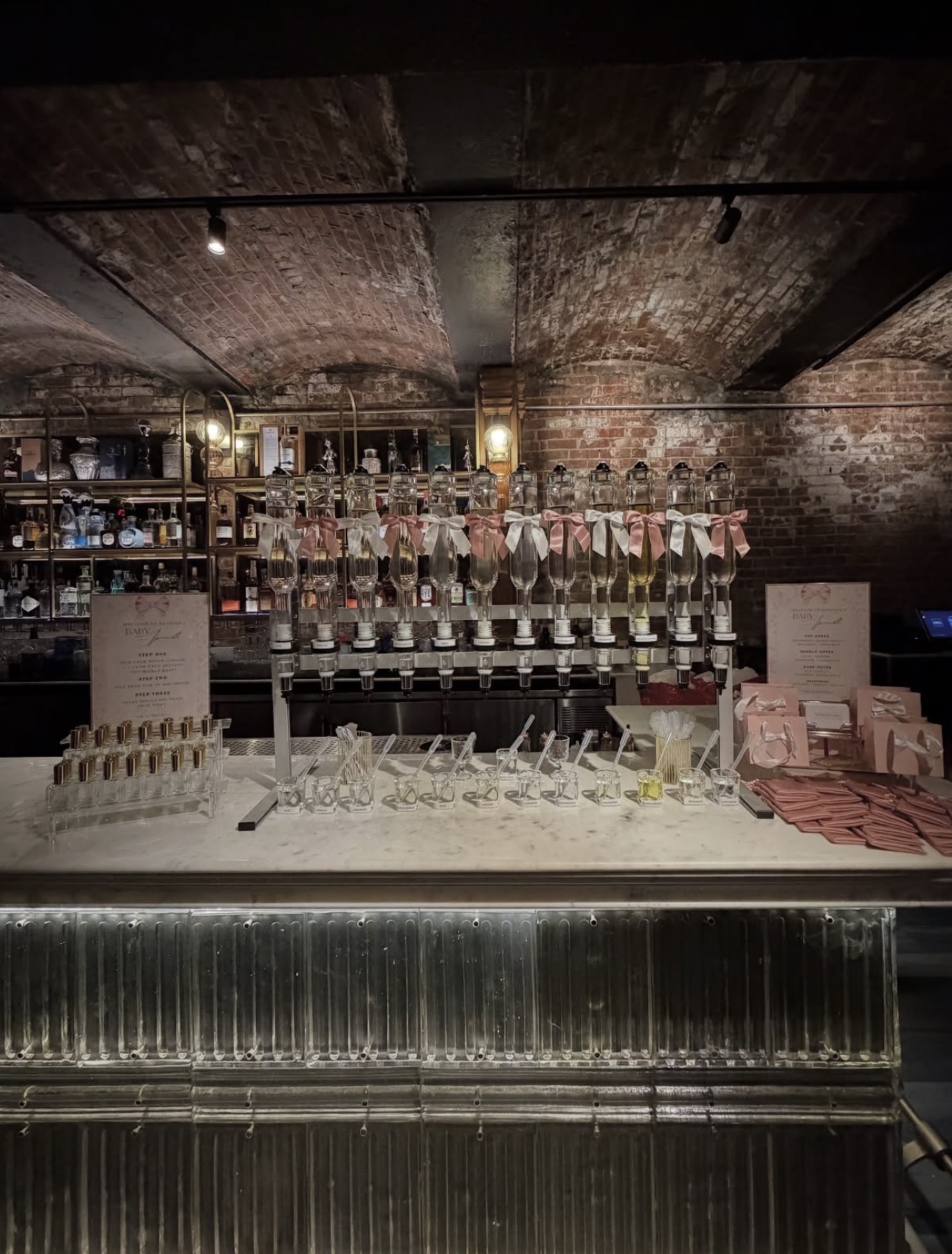 Create-your-own fragrance bar with ribboned bottles in a candlelit cellar